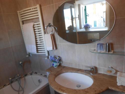 a bathroom with a sink and a mirror and a tub at La Torretta Historical Home in Casperia