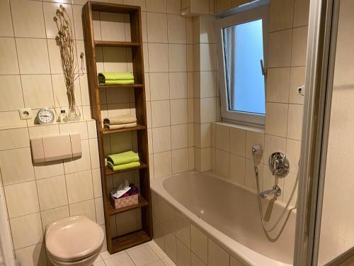 y baño con bañera, aseo y lavamanos. en Ferienwohnung am Obstgarten, en Bad Bocklet