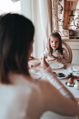 a woman sitting at a table with a little girl at Hotel Finkennest - Panoramic Garden Resort in Schenna