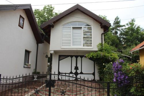 a white house with a black fence at Art apartman in Kakanj