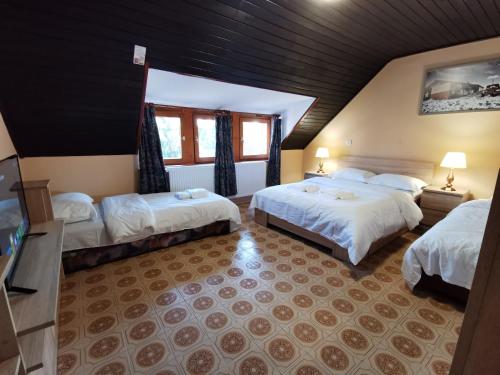 Habitación de hotel con 2 camas y ventana en Ambient Deluxe Apartman, en Gyula