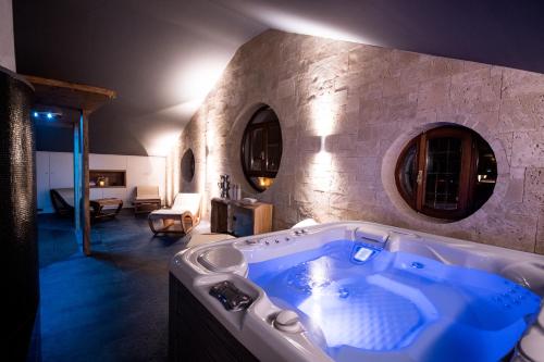 a large bath tub in a room with a stone wall at Relais Santo Stefano in Sandigliano