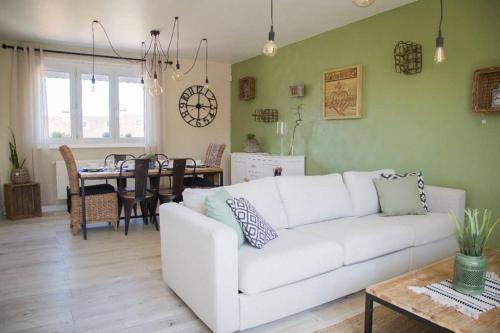 uma sala de estar com um sofá branco e uma mesa em TRES JOLIE MAISON A COTE DE LA PLAGE em Le Portel