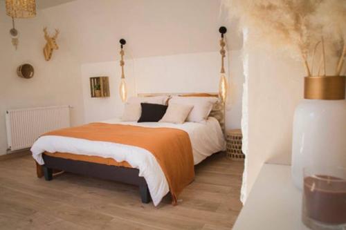 une chambre avec un grand lit avec une couverture orange dans l'établissement TRES JOLIE MAISON A COTE DE LA PLAGE, à Le Portel