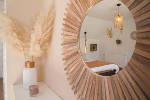 a circular mirror on a wall in a room at TRES JOLIE MAISON A COTE DE LA PLAGE in Le Portel