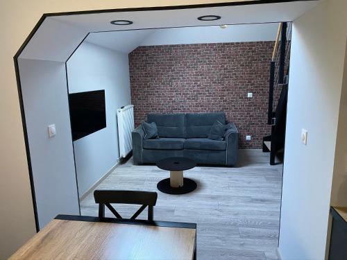 a living room with a blue couch and a mirror at Logements équipés à Onnaing avec espace Balneo en OPTION proche Toyota, autoroute et Valenciennes in Onnaing