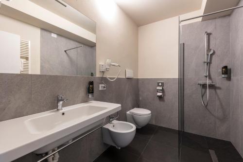 a bathroom with a sink and a toilet and a shower at Arco Smart Hotel in Arco