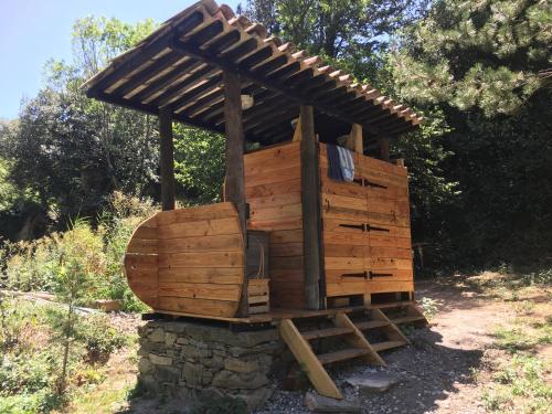 une structure en bois avec un toit en haut dans l'établissement Moulin de la Buade, à Termes