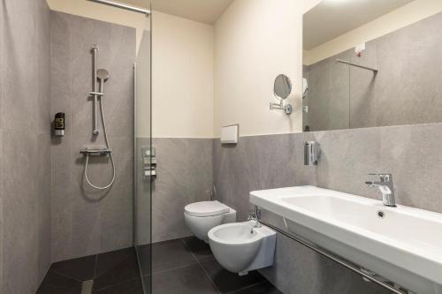 a bathroom with a sink and a toilet and a shower at Arco Smart Hotel in Arco