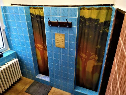 a bathroom with a blue tiled shower with curtains at Chata Šumná in Pustevny