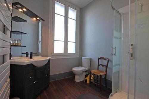 a bathroom with a sink and a toilet and a window at Normandie 12 couchages in LʼAigle
