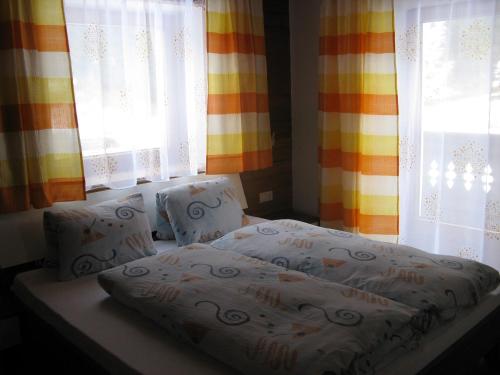 a bed sitting in a room with windows at Ferienwohnung Wohlfarter in Jerzens