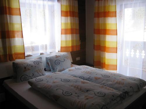 a bed sitting in a room with windows at Ferienwohnung Wohlfarter in Jerzens
