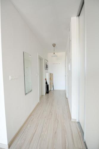 an empty hallway with white walls and wood floors at Apartmán Centroom in Piešťany