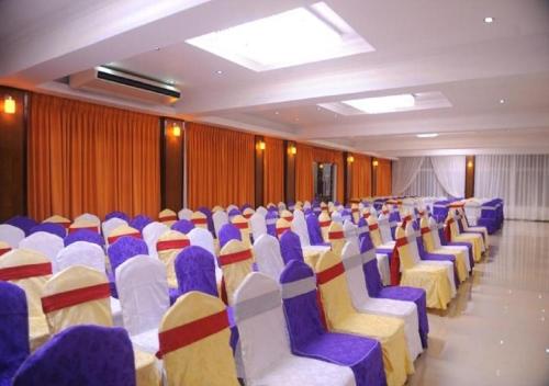 a room with blue and white chairs and curtains at Hotel East Lagoon in Batticaloa