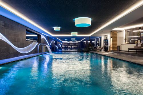 a pool in a hotel room with a water slide at DAS GERSTL Alpine Retreat in Malles Venosta
