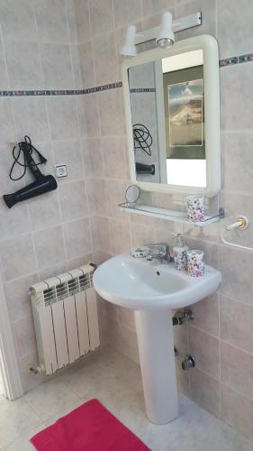 a bathroom with a white sink and a mirror at Apartment Los Eucaliptus in L'Eucaliptus