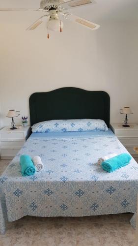 a bedroom with a bed with blue sheets and blue pillows at Apartment Los Eucaliptus in L'Eucaliptus