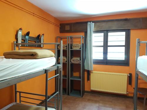 a room with three bunk beds and a window at Alberg Les Daines in Espot