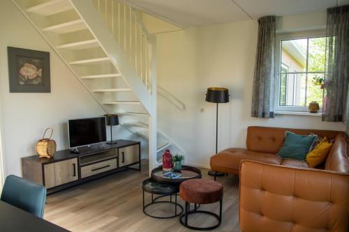 a living room with a couch and a staircase at de Putter in Hollum