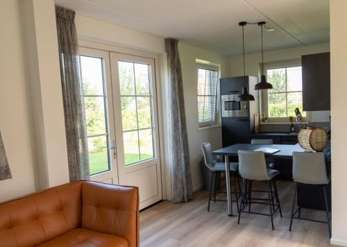 a living room and kitchen with a table and chairs at de Putter in Hollum