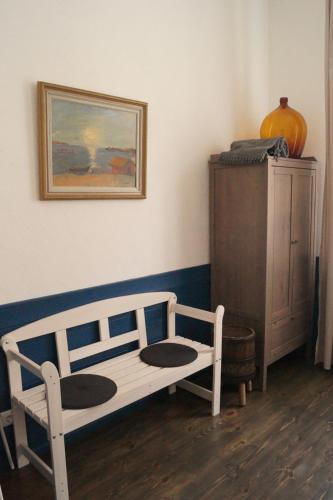 a bedroom with a bed and a dresser and a painting at DABA Mini Hotel in Rīga