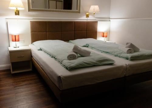 a bedroom with a large bed with two pillows on it at G&H Hotel Rosengarten in Rosengarten