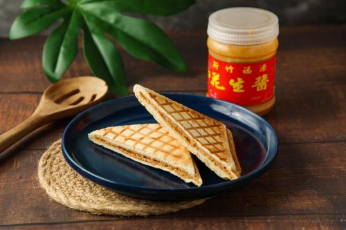 a blue plate with two waffle sandwiches and a jar of honey at 花蓮亮君經典民宿1館加2館民宿-東大門夜市-電梯包棟Bright King Homestay in Hualien City