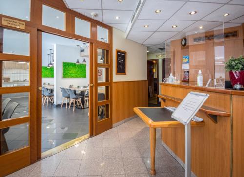 a restaurant with a counter and a dining room at Hotel Orion in Budapest