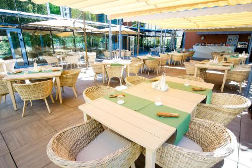a restaurant with tables and chairs and windows at Pleiada Boutique Hotel & Spa in Iaşi