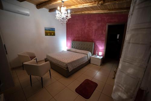 a bedroom with a bed and a chandelier at L'orangerie in Capo dʼOrlando