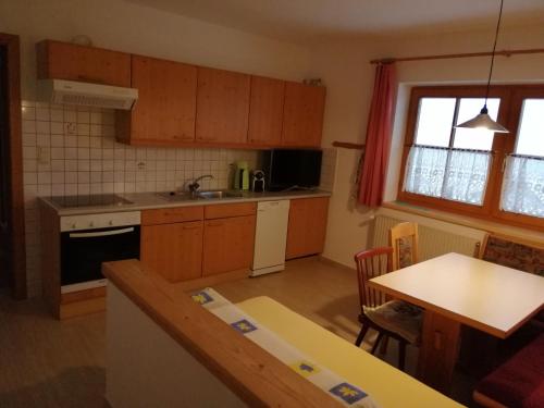 a kitchen with wooden cabinets and a table with a tableablish at Alpenhaus Christian in Neustift im Stubaital