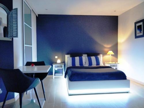 a bedroom with a bed and a table and a desk at Chez Victoria Nantes Erdre in Nantes