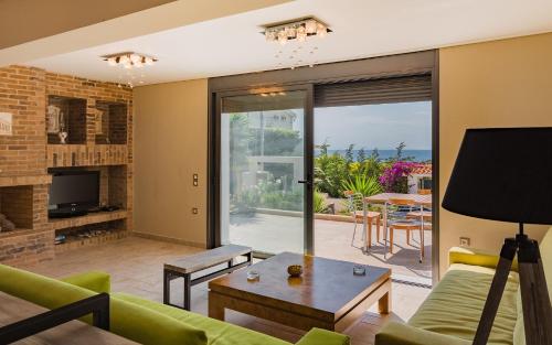 a living room with a couch and a table at Adam & Eve Villas in Sounio