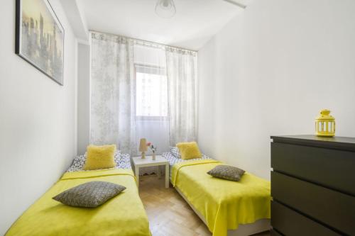 ワルシャワにあるGama Great Location & Famili Apartment 120m 2-12 peopleのベッドルーム1室(黄色いシーツと窓付)