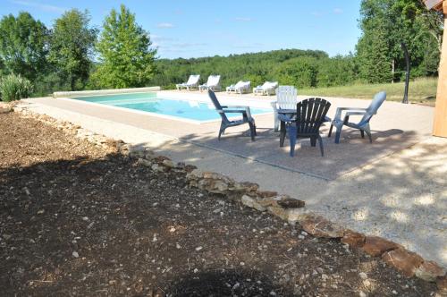 a patio with a table and chairs next to a pool at Gîte pour 4 personnes - Dordogne in Bressac