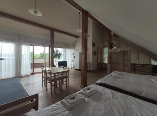 - une chambre avec deux lits et une salle à manger avec une table dans l'établissement Vikingu guest house, à Jurmala