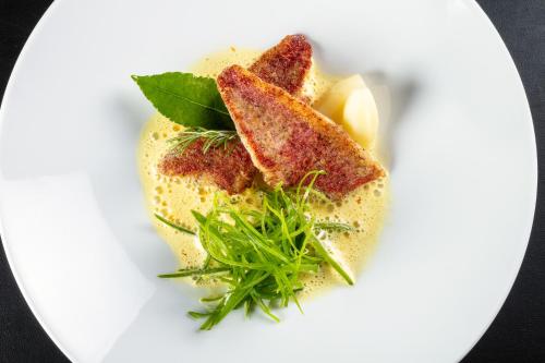 a white plate with some food on it at Le Pré du Moulin - Maison Alonso - Hôtel & Restaurant in Sérignan-du-Comtat