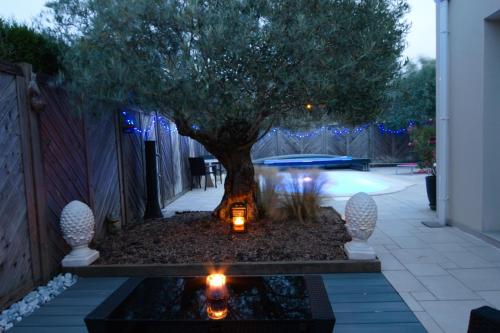 a garden with a tree and candles in a pond at Chez Victoria Nantes Erdre in Nantes