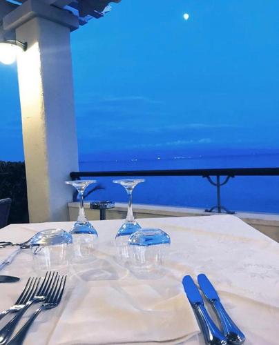 a table with a white table cloth with wine glasses on it at Hotel Ristorante La Lampara in Gizzeria