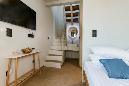 a bedroom with a bed and a staircase with a mirror at Lindos Calmare Suites in Lindos