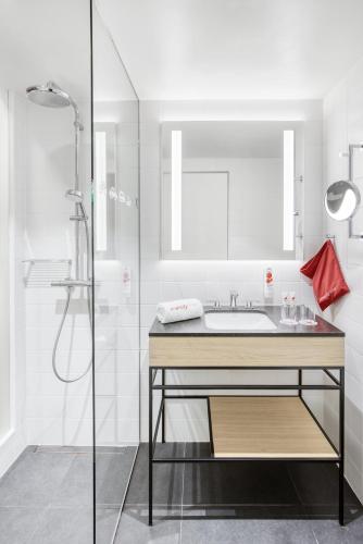 a bathroom with a sink and a shower at IntercityHotel Saarbrücken in Saarbrücken