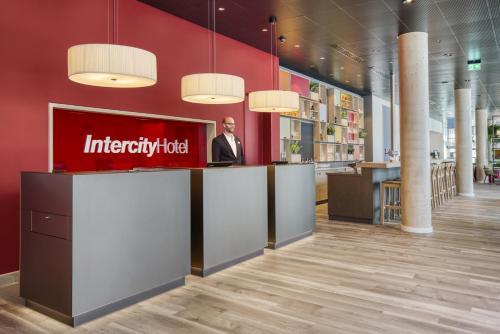 a man standing at a counter in a store lobby at IntercityHotel Saarbrücken in Saarbrücken