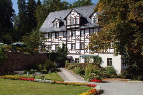 a large white building with a black roof at Rehaklinik Thermalbad Wiesenbad in Thermalbad Wiesenbad