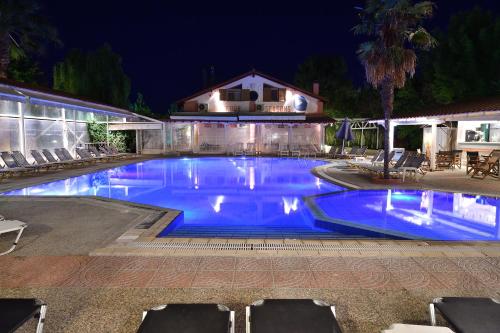 a large swimming pool with blue water at night at Four Seasons Hotel in Trílofon