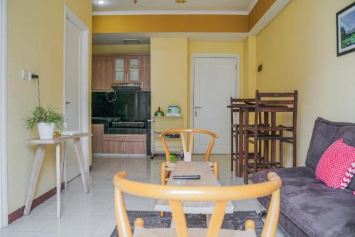 a living room with a couch and a table at Tidy 2BR Apartment at Silkwood Residences near BINUS By Travelio in Tangerang