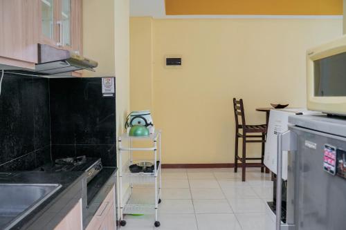 a kitchen with a cart with a tea pot on it at Tidy 2BR Apartment at Silkwood Residences near BINUS By Travelio in Tangerang