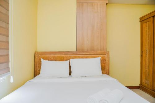 a bedroom with a bed with two white pillows at Tidy 2BR Apartment at Silkwood Residences near BINUS By Travelio in Tangerang