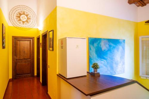 a kitchen with yellow walls and a refrigerator at La casa di Pilar in Cotignola
