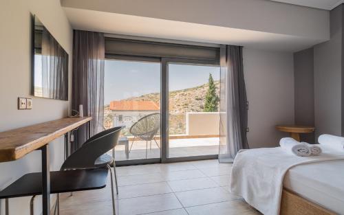 a hotel room with a bed and a large window at Adam & Eve Villas in Sounio